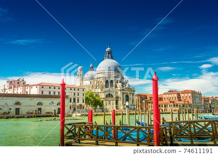 Colorful view of Basilica di Santa Maria della Salute and busy Grand Canal at sunset, Venice, Italy, summer time Colorful view of Basilica di Santa Maria della Salute and busy Grand Canal at sunset, Venice, Italy, summer time 74611191