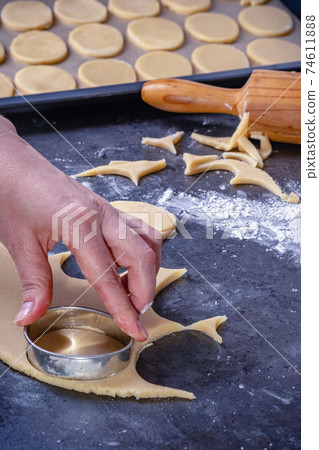 Woman prepares butter cookies at home in the kitchen Woman prepares butter cookies at home in the kitchen 74611888