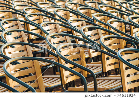 Wooden chairs. Empty stools without people. Concept photo - absence of audience. Wooden chairs. Empty stools without people. Concept photo - absence of audience. 74611924