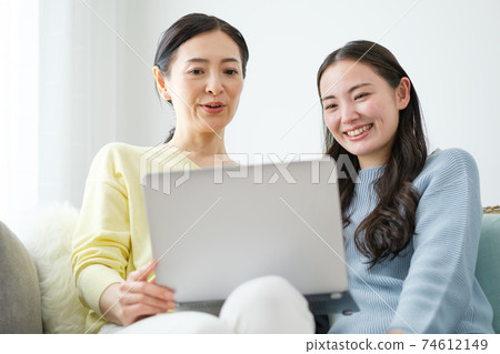 父母和孩子在客廳裡使用個人電腦 父母和孩子在客廳裡使用個人電腦 74612149