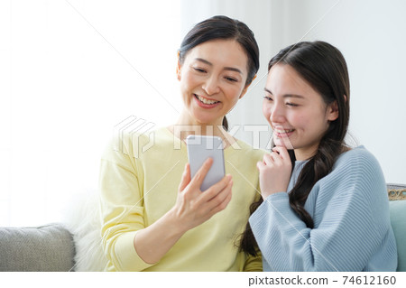 Parents and children using smartphones in the living room Parents and children using smartphones in the living room 74612160