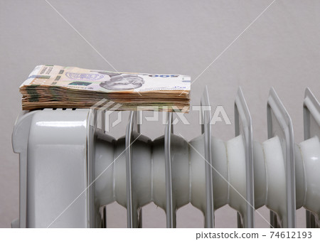 stack of banknotes on an electric heating radiator stack of banknotes on an electric heating radiator 74612193