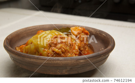 bell pepper stuffed with meat and rice in red tomato sauce on a plate. bell pepper stuffed with meat and rice in red tomato sauce on a plate. 74612194