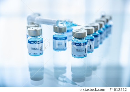 Ampoules with Covid-19 vaccine on a laboratory bench. 74612212