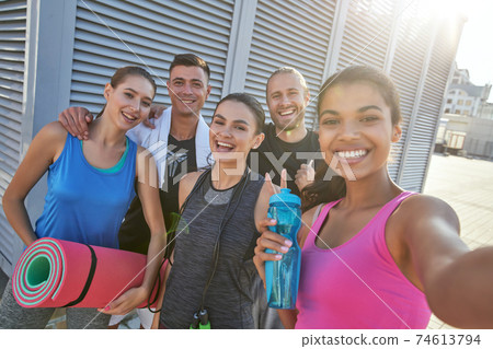 Group of young mixed race girls and men taking selfie Group of young mixed race girls and men taking selfie 74613794