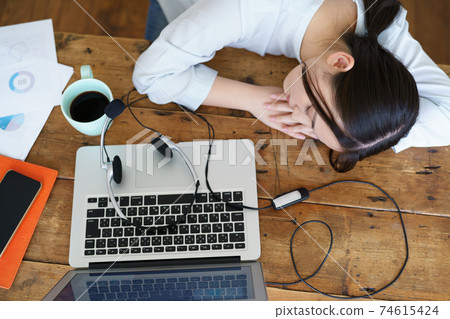 一個年輕的女人，在遠程辦公之間打na 74615424