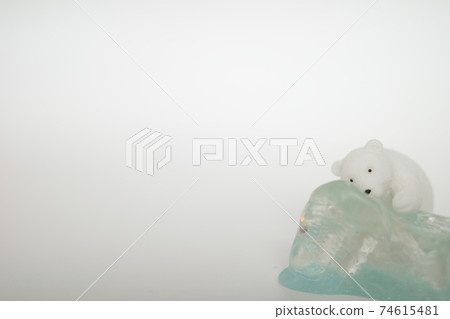 Polar bear figurine leaning against ice Polar bear figurine leaning against ice 74615481