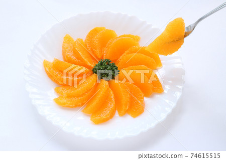 Cut decopon on a white plate on a white background and decopon stabbed in a fork Cut decopon on a white plate on a white background and decopon stabbed in a fork 74615515