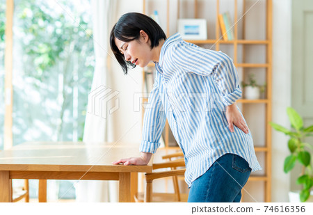 Young woman with a backache 74616356