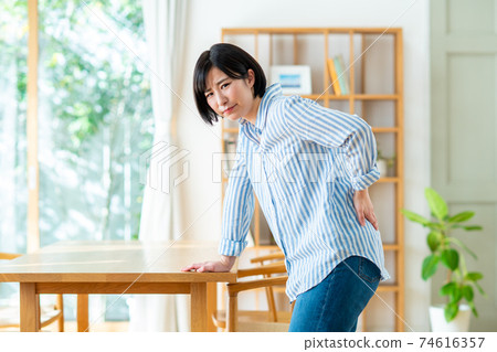 Young woman with a backache Young woman with a backache 74616357