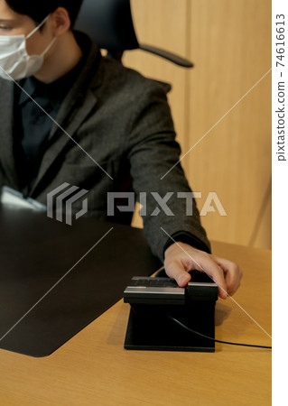A businessman trying to pick up the handset 74616613