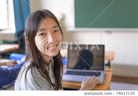happy asian Student girl  using  laptop in classroom 74617130