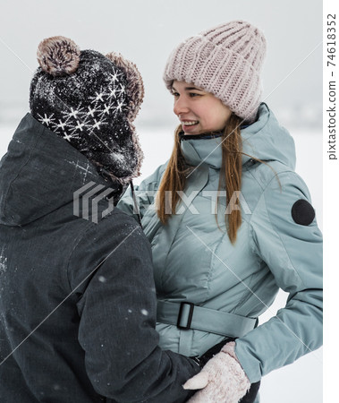 Portrait of smiling couple in love looking at each other. Young happy couple walking in winter 74618352