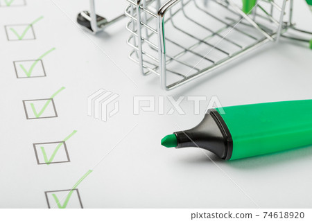 Supermarket Cart and Green Marker Marked on the Checklist Sheet. Supermarket Cart and Green Marker Marked on the Checklist Sheet. 74618920