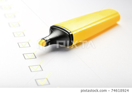 Yellow marker with markers on the checklist sheet. Yellow marker with markers on the checklist sheet. 74618924