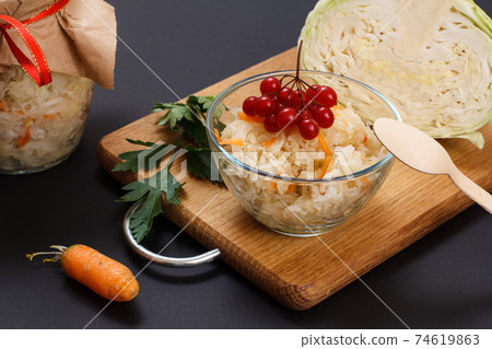 Fermented cabbage with herbs and spices in glass bowl on the black background Fermented cabbage with herbs and spices in glass bowl on the black background 74619863