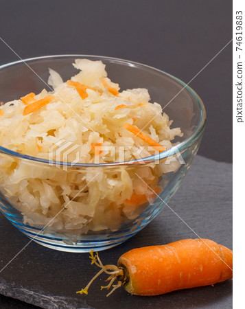 Fermented cabbage with herbs and spices in glass bowl on the black background Fermented cabbage with herbs and spices in glass bowl on the black background 74619883