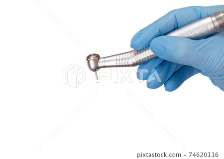 Dentist's hand in glove with dental handpiece. Dentist's hand in glove with dental handpiece. 74620116