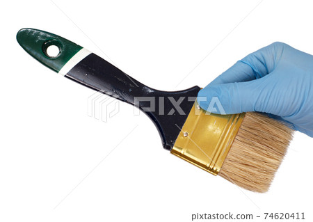 Woman holding painter brush on a white isolated background. Repair tool. Woman holding painter brush on a white isolated background. Repair tool. 74620411