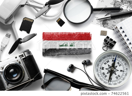 Flag of Iraq and travel accessories on a white background. Flag of Iraq and travel accessories on a white background. 74622561