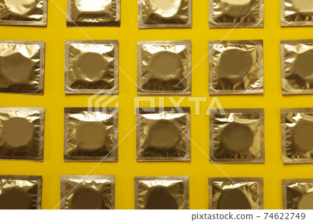 Condoms on yellow background Condoms on yellow background 74622749