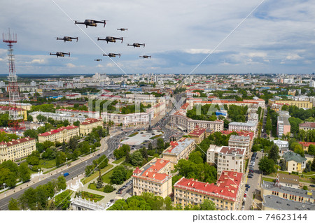 Drones fly over a residential city. Urban landscape with drones flying over it, quadrocopters 74623144