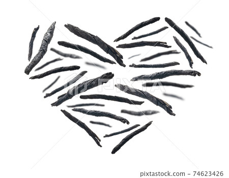 Dry twisted leaves of Kuding tea in the shape of a heart on a white background 74623426