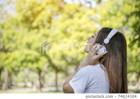Leisure cheerful wellness woman Concept. Happy teenage woman listening to music wear headphones 74624104