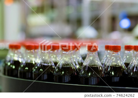 View of plastic bottles at bottling line at soft drinks factory View of plastic bottles at bottling line at soft drinks factory 74624262