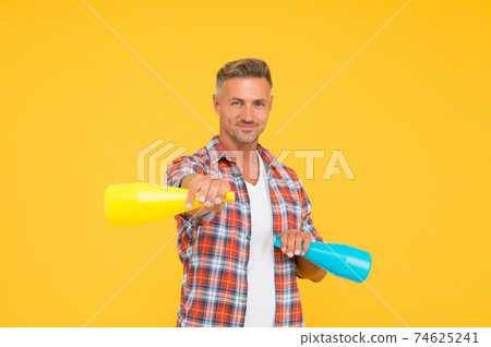 Clean house. Happy man hold household sprays. Cleaning 74625241