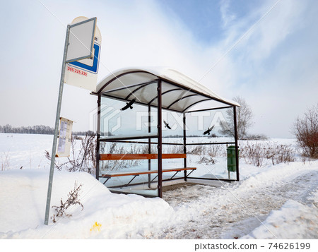 Empty suburban bus stop covered with snow in winter. Slipery pavement Empty suburban bus stop covered with snow in winter. Slipery pavement 74626199