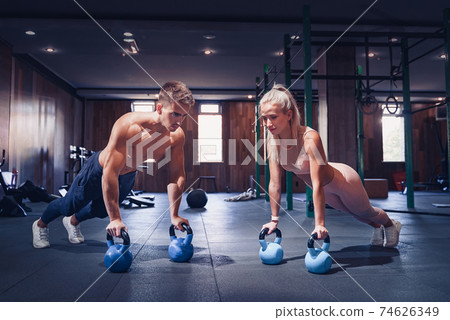 Young couple is working out at gym. Attractive woman and handsom 74626349