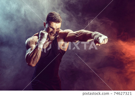 Sportsman boxer fighting on black background with shadow. Copy Space. Boxing sport concept. Sportsman boxer fighting on black background with shadow. Copy Space. Boxing sport concept. 74627321