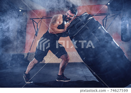 Bodybuilding training, bearded strong sportsman with muscular bo 74627599