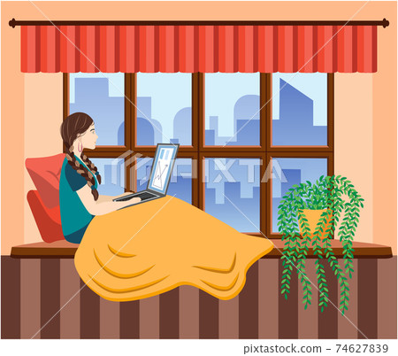 A woman works at a laptop while sitting on the windowsill at home. Freelance concept, quarantine due to covid-19. 74627839