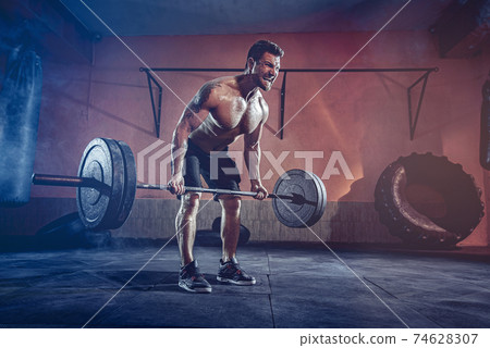 Muscular man working out in gym doing exercises, strong male naked torso abs Muscular man working out in gym doing exercises, strong male naked torso abs 74628307