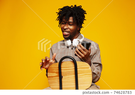 young handsome african american guy student posing cheerful and gesturing on yellow background, lifestyle people concept 74628783
