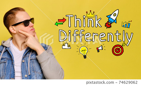 Think differently concept - young guy smiling on yellow background. 74629062