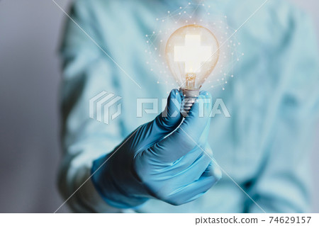 Healthcare idea concept with charts and a doctor holding a light bulb. Healthcare idea concept with charts and a doctor holding a light bulb. 74629157