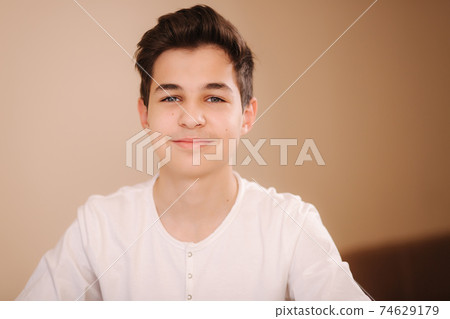 Portrait of young smiled teenage boy in white sweatshirt. Hppy handsome boy after playing games Portrait of young smiled teenage boy in white sweatshirt. Hppy handsome boy after playing games 74629179