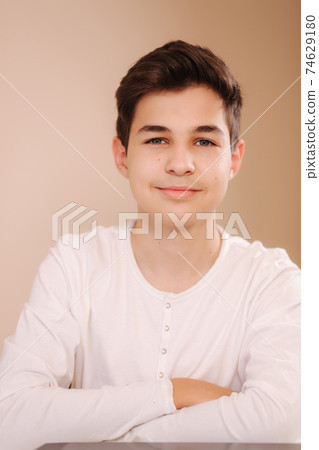 Portrait of young smiled teenage boy in white sweatshirt. Hppy handsome boy after playing games Portrait of young smiled teenage boy in white sweatshirt. Hppy handsome boy after playing games 74629180