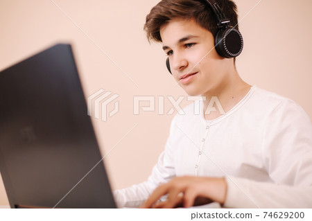 Teenage boy playing game on laptop in his room. Steamer use wireless headphones. Boy stay at home and play all day 74629200