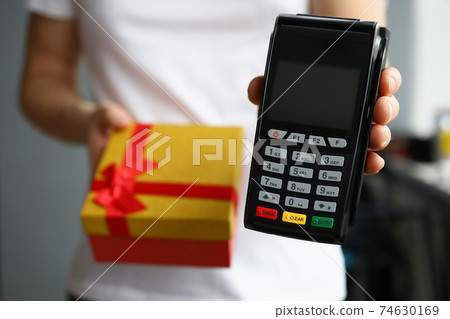 Courier is holding gift box and payment terminal 74630169