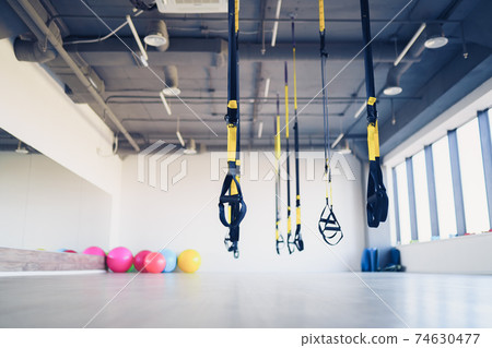 Trx fitness straps for working with own weight in gym, no people 74630477
