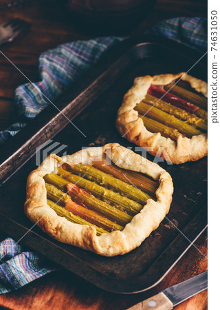 Rhubarb mini galettes on baking sheet 74631050