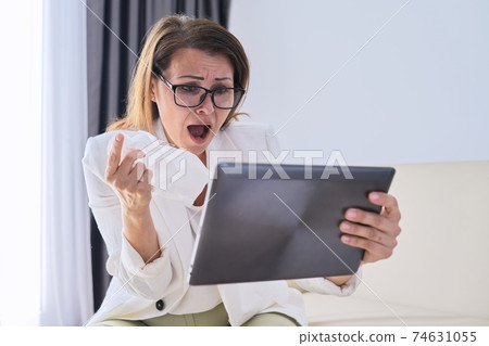 Sick businesswoman sneezing in handkerchief making video call Sick businesswoman sneezing in handkerchief making video call 74631055