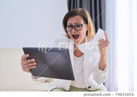Sick business woman sneezing into handkerchief makes video call to doctor Sick business woman sneezing into handkerchief makes video call to doctor 74631058