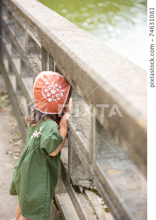 Child staring at the river Child staring at the river 74631081