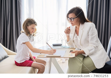 Child psychologist talking to girl kid in office Child psychologist talking to girl kid in office 74631253
