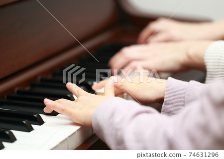 5-year-old girl and mom playing an upright piano 74631296